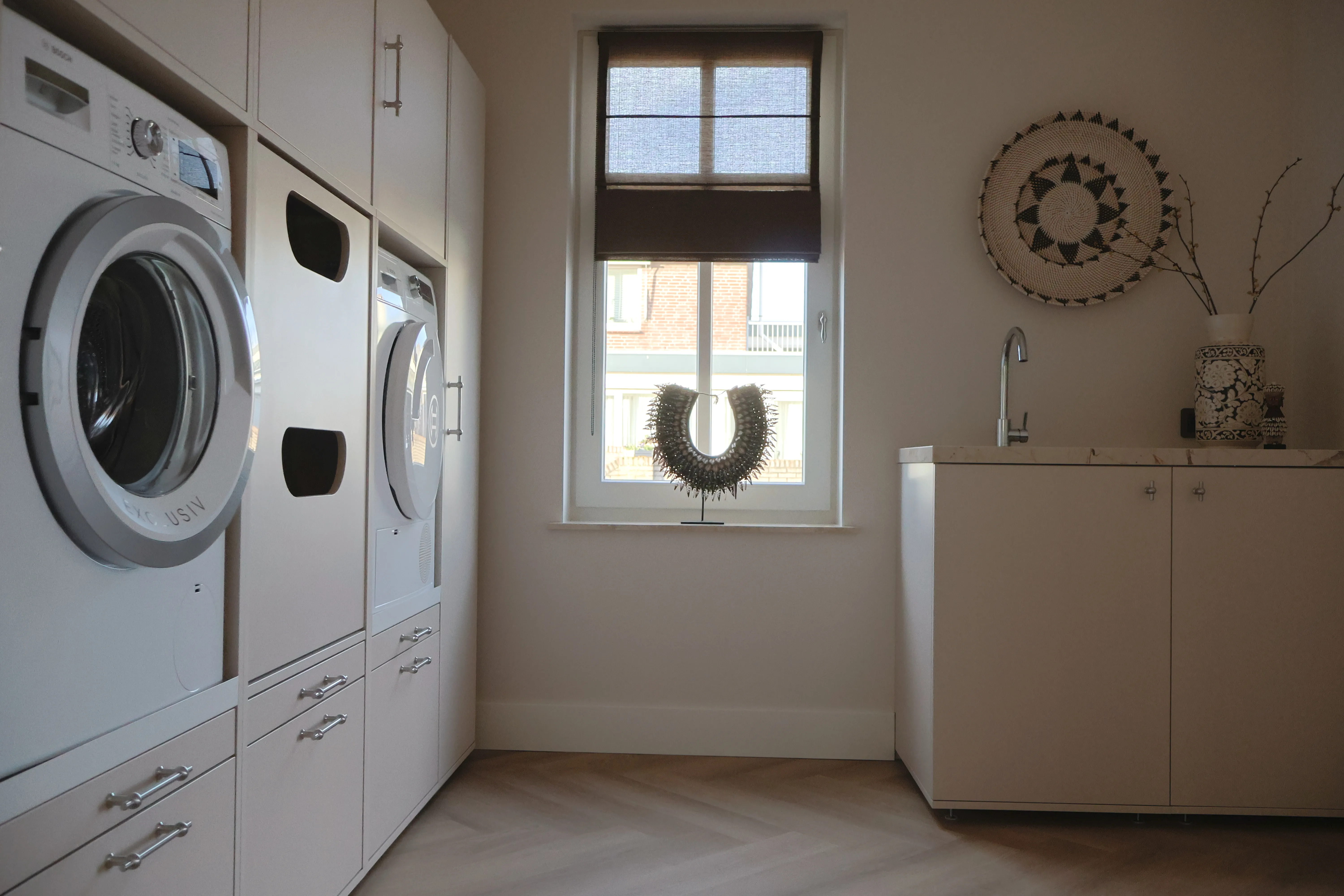 Wasmachine kast in de bijkeuken in de kleur cashmere beige met onderkasten en gootsteen